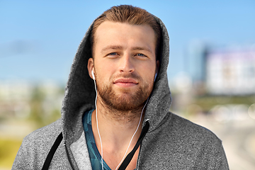 Image showing man in earphones listening to music outdoors