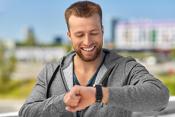 Image showing happy man with fitness tracker in city