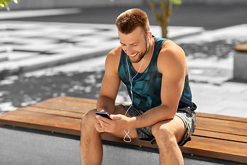 Image showing young athlete man with earphones and smartphone