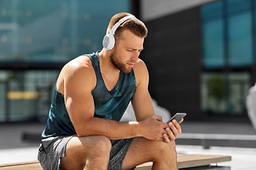 Image showing young athlete man with headphones and smartphone