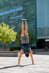 Image showing young man exercising and doing handstand outdoors