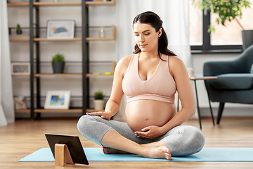 Image showing pregnant woman with tablet pc doing sports at home