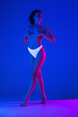 Image showing Beautiful female body on blue background in neon light. Beauty, cosmetics, spa, depilation, diet and treatment, fitness concept.