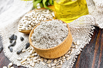 Image showing Flour sunflower in bowl with oil on wooden board