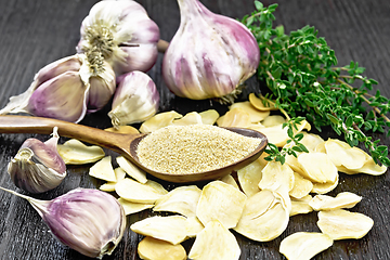 Image showing Garlic ground in spoon on dark board