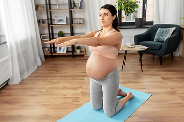 Image showing happy pregnant woman doing sports at home