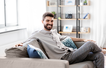 Image showing happy smiling man sitting on sofa at home