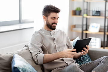 Image showing smiling man with tablet computer at home