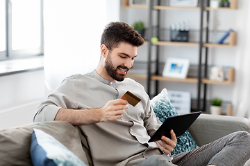 Image showing man with tablet computer and credit card at home