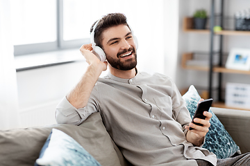 Image showing man in headphones listening to music on smartphone