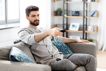 Image showing man with remote control watching tv at home