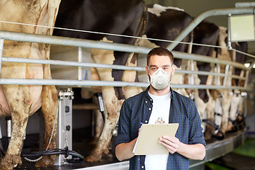 Image showing man in mask with clipboard and cows on dairy farm