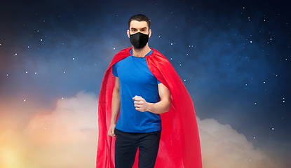 Image showing man in red superhero cape and black mask at night