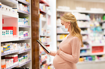 Image showing pregnant woman in mask with tablet pc at pharmacy