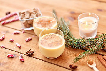 Image showing glasses of eggnog, ingredients and spices on wood