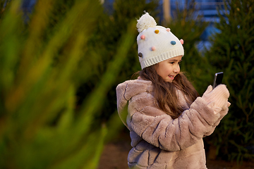 Image showing girl with smartphone at christmas tree market