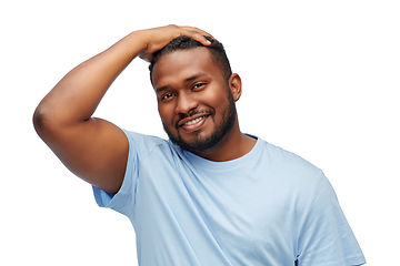 Image showing smiling young african american man touching hair