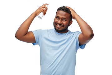 Image showing african american man applying hairspray to hair