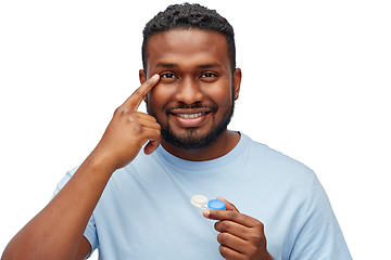 Image showing young african american man applying contact lenses