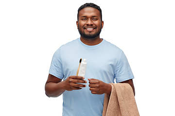 Image showing smiling man with toothbrush, toothpaste and towel