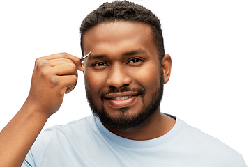 Image showing african man with tweezers tweezing his eyebrow