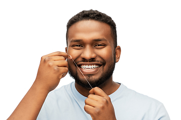 Image showing happy african man with dental floss cleaning teeth