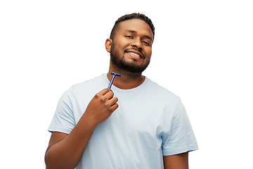 Image showing smiling african man shaving beard with razor blade