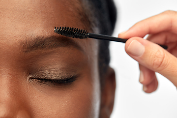 Image showing face of african woman and hand with mascara brush