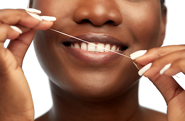 Image showing african woman cleaning teeth with dental floss