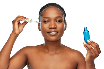 Image showing african american woman with bottle of serum