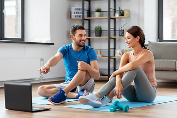 Image showing happy couple with laptop doing sports at home