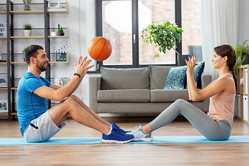 Image showing happy couple exercising with ball at home