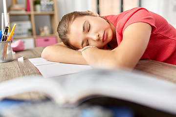 Image showing tired student girl sleeping on table at home