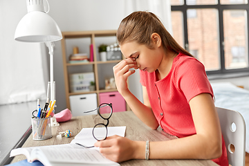 Image showing tired teenage student girl with glasses at home