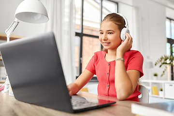 Image showing girl in headphones with laptop computer at home