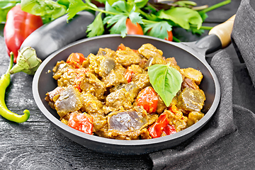 Image showing Meat with eggplant and pepper in pan on board