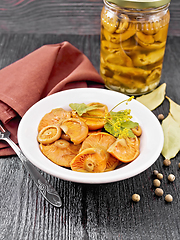 Image showing Mushrooms salted in plate on wooden board