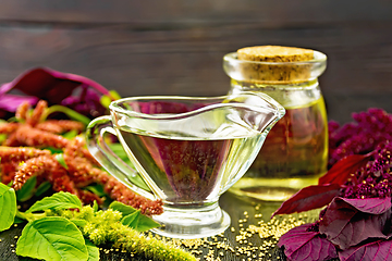 Image showing Oil amaranth in gravy boat on dark board