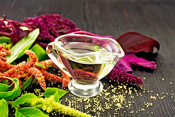 Image showing Oil amaranth in gravy boat on wooden board