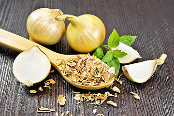 Image showing Onion flakes in spoon on wooden board