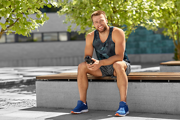 Image showing happy sportsman with bottle sitting on city bench