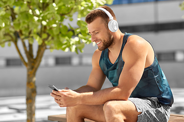 Image showing young athlete man with headphones and smartphone