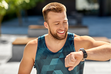 Image showing happy man with fitness tracker in city