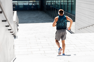 Image showing young man in headphones running downstairs