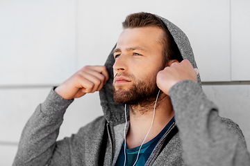 Image showing man in earphones listening to music outdoors