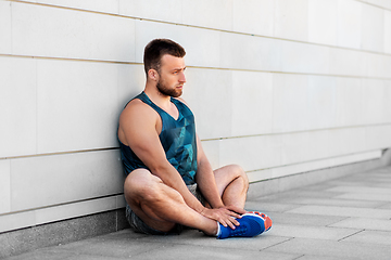 Image showing man doing sports and stretching outdoors