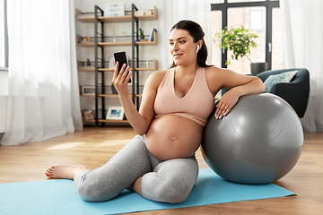 Image showing pregnant woman with smartphone and fitball at home