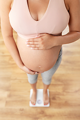 Image showing close up of pregnant woman standing on scales