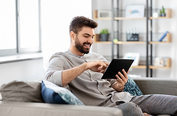 Image showing smiling man with tablet computer at home