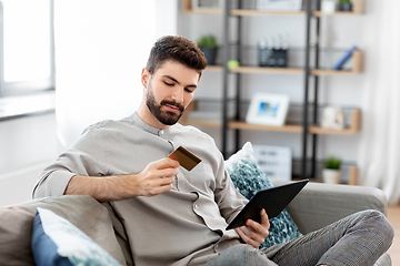 Image showing man with tablet computer and credit card at home